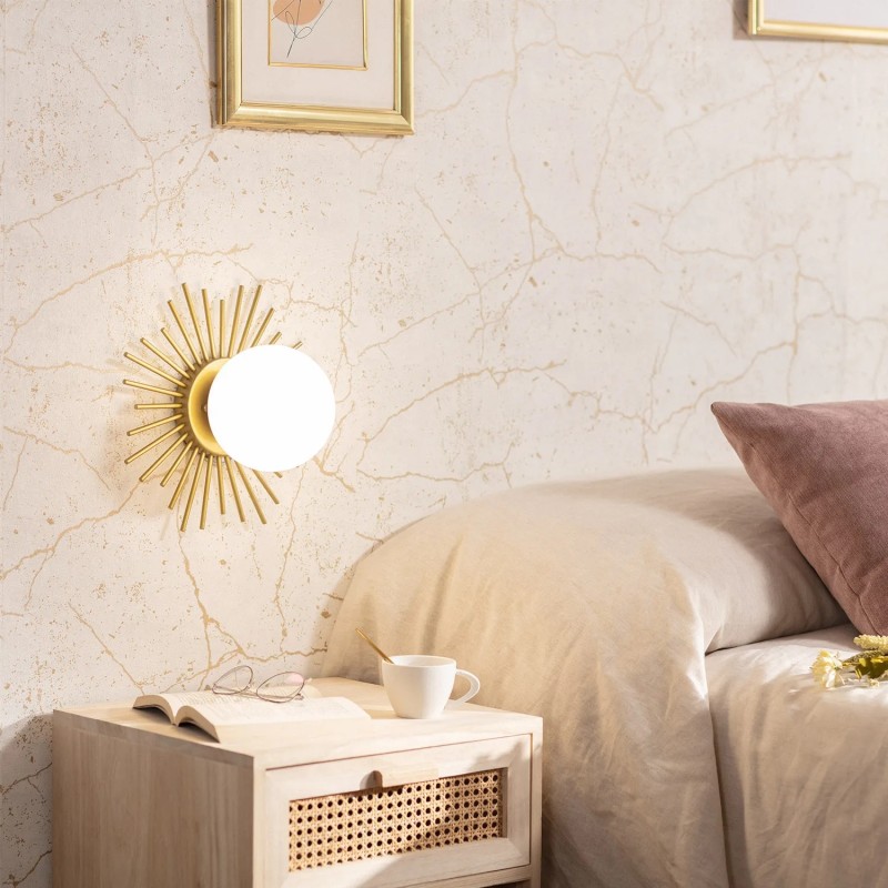 Złoty kinkiet z białą kulą do sypialni