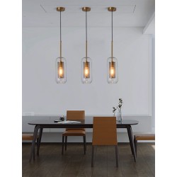 trzy Lampy Wiszące Złote ze Szklanym kloszem Nobbile nad stołem na tle szarej ściany