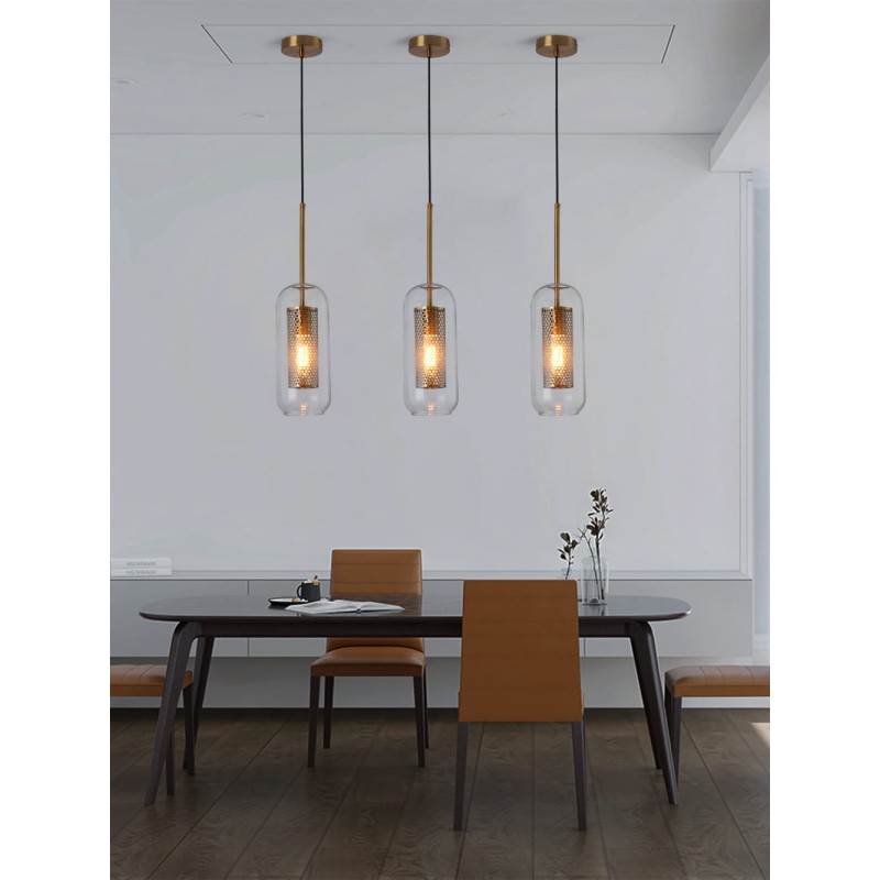 trzy Lampy Wiszące Złote ze Szklanym kloszem Nobbile nad stołem na tle szarej ściany